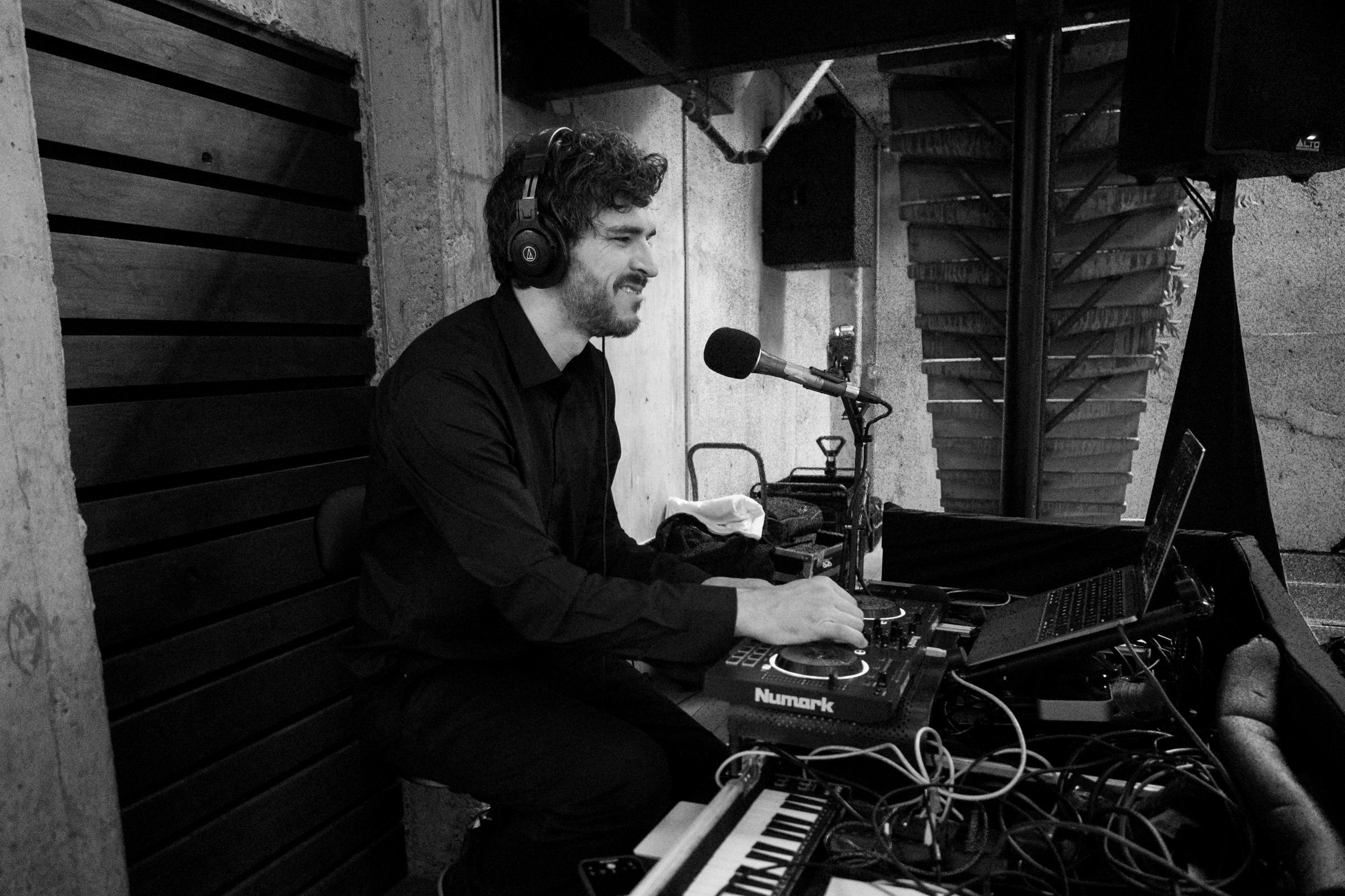 Jacob Black smiling at the decks, headphones on
